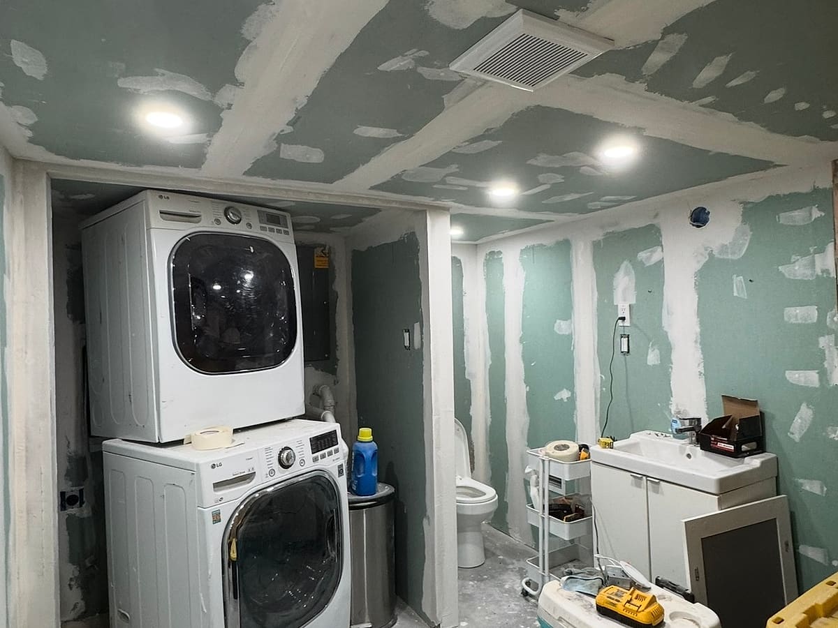 Basement laundry area with taped drywall